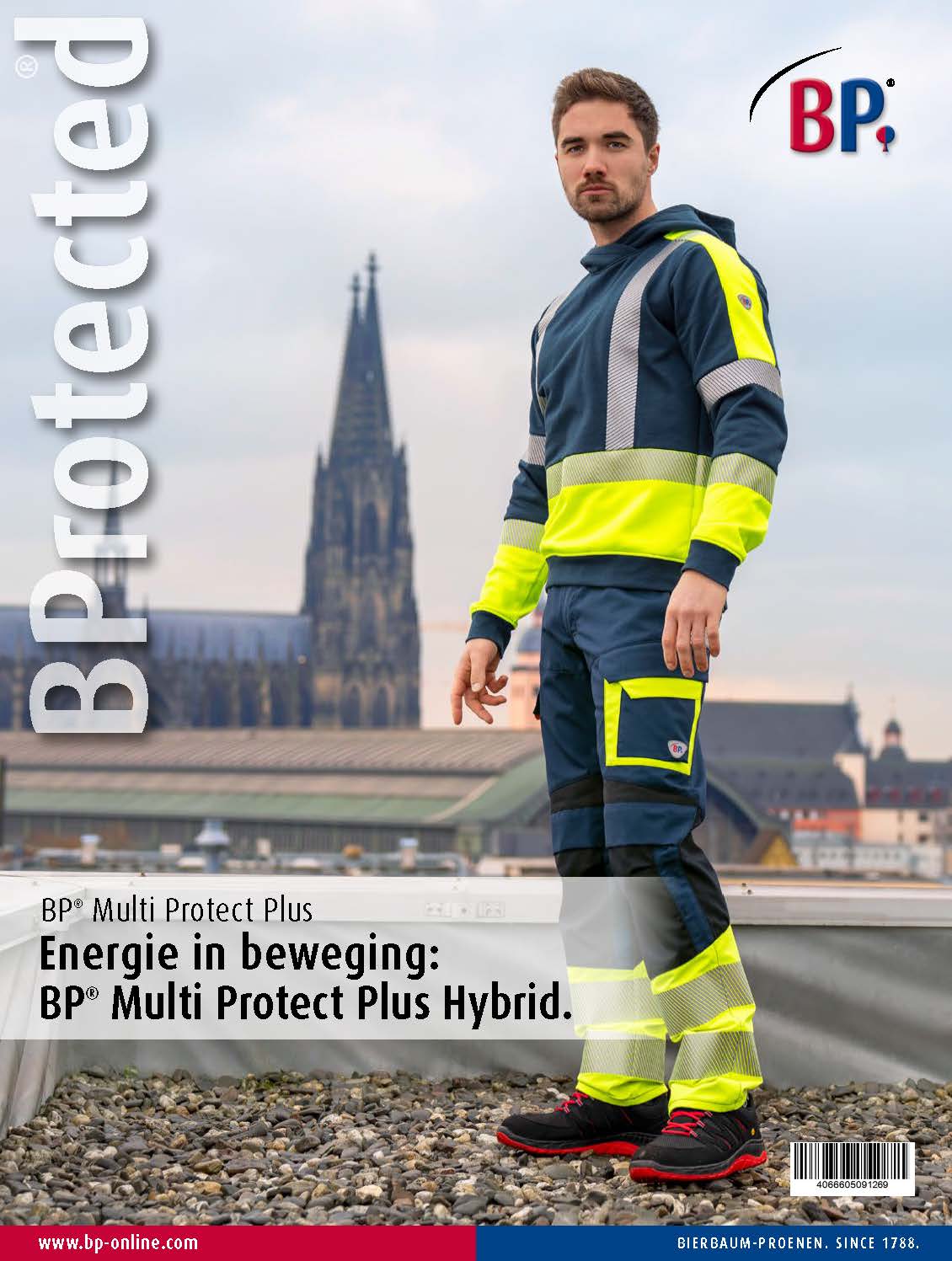 A man wears MultiProtectPlus clothing and stands on a roof with Cologne Cathedral in the background.
